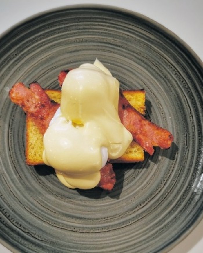 Poached eggs, hollandaise and bacon on toasted bread at The River Cafe